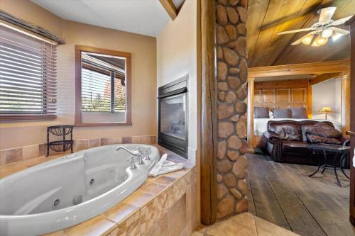 a large bathroom with a tub and a bedroom at Adobe Village Studio Suite- Sundance in Oak Creek