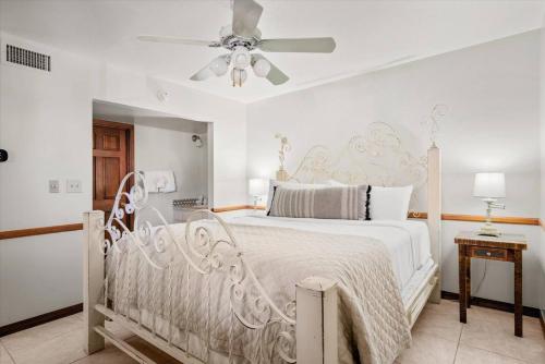 ein Schlafzimmer mit einem weißen Bett mit Deckenventilator in der Unterkunft Studio Suite- Country in Oak Creek