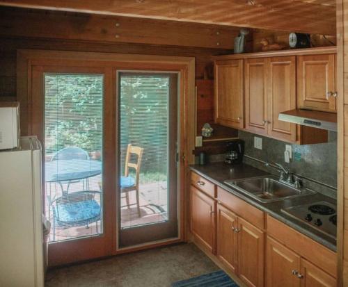 een keuken met een glazen schuifdeur naar een patio bij Rustic Cabin for 2 in Oak Creek Cabin - WILD ROSE in Indian Gardens