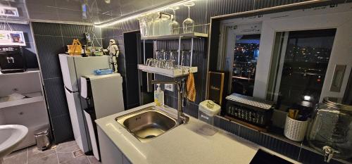 a kitchen with a sink and a window with a city at BinsHeim HBC - Seoul's Aesthetic Stay with the best Night view Rooftop in Seoul