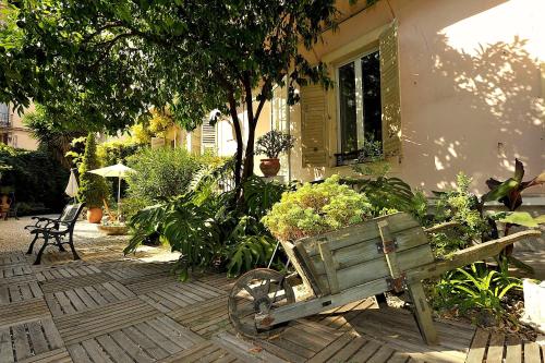 um velho carrinho de madeira com vasos de plantas num pátio em Nice Garden Hotel em Nice