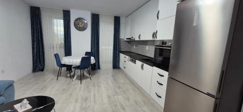 a kitchen with a refrigerator and a table with chairs at Szabo Georgiana in Alba Iulia