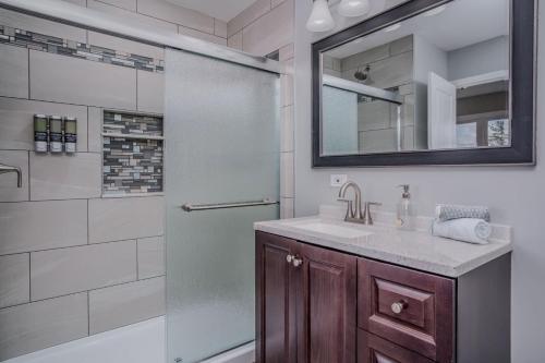 un bagno con doccia, lavandino e specchio di 3BR 2BTH Waterfront Vacation Rental on Riverwalk to Downtown McHenry with Pier a McHenry