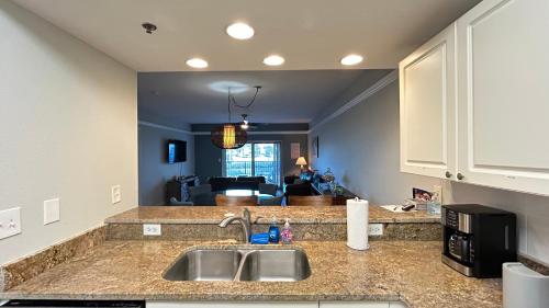 a kitchen with a sink and a living room at Seashell Escape in New Smyrna Beach