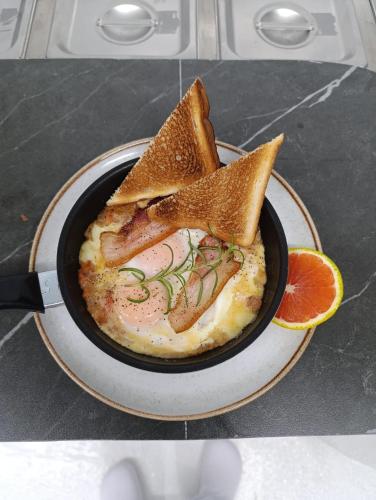 a plate with a bowl of food with two pieces of bread at Hotel Rulay Medellin in Medellín