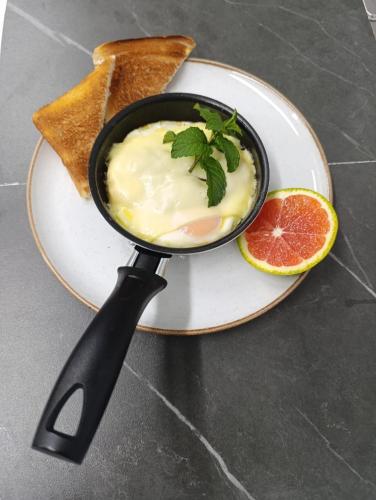 a black bowl of food on a plate with toast at Hotel Rulay Medellin in Medellín