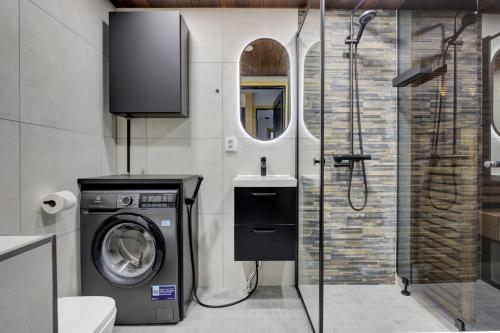 y baño con lavadora y ducha. en Deluxe Luosto, en Luosto