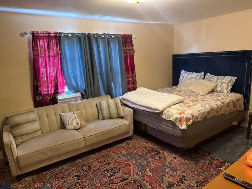 ein Schlafzimmer mit einem Bett, einem Sofa und Vorhängen in der Unterkunft 3 Large Bedroom Pool Table Spacious in Hillside