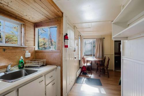 una piccola cucina con un lavello e un tavolo di 2-Bedroom Cottage #3 - Sugar Pine a Gravenhurst
