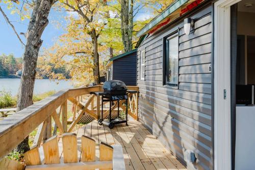 a grill on a deck next to a house at Studio Cottage #8 - Jack Pine in Gravenhurst