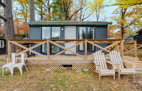 a tiny house with a deck and two chairs at Studio Cottage #9 - Virginia Pine in Gravenhurst