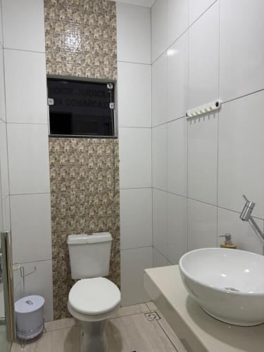 un bagno con un water bianco e un lavandino di Apto Serras Gerais 2 a Dianópolis