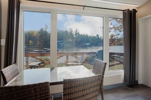 une salle à manger avec une table et une grande fenêtre dans l'établissement 2-Bedroom Cottage #10 - Pitch Pine, à Gravenhurst
