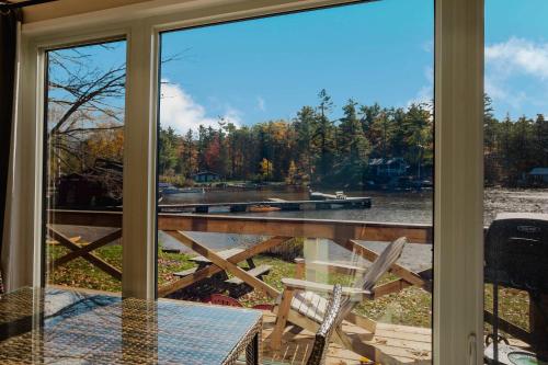 un porche grillagé avec une table et une chaise dans l'établissement 2-Bedroom Cottage #10 - Pitch Pine, à Gravenhurst