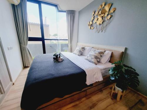 a bedroom with a large bed in a room with a window at Cityscape Bliss Phuket in Ban Sam Kong