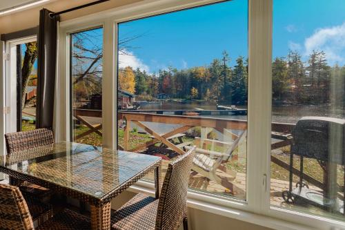eine abgeschirmte Veranda mit einem Tisch, Stühlen und einem Fenster in der Unterkunft 2-Bedroom Cottage #11 - Red Pine in Gravenhurst
