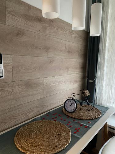 a table with a clock and a bicycle on it at Szeged Sunshine Apartman in Szeged