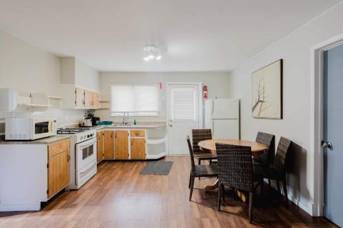 eine Küche mit weißen Geräten sowie einem Tisch und Stühlen in der Unterkunft Pine Lake 3-Bedroom Cottage #12 - The Gallery in Gravenhurst
