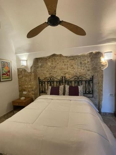 a bedroom with a large bed with a ceiling fan at Casa Dea - Bungalow Aphrodite in Hammamet Sud
