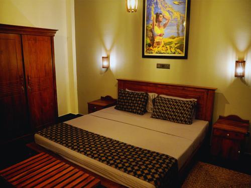 a bedroom with a bed and a picture on the wall at BREATHE Collections Habaraduwa in Habaraduwa