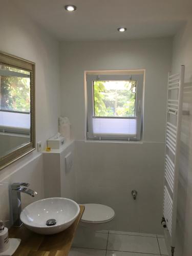 a white bathroom with a sink and a window at Landhaus am Deich in Cluvenhagen