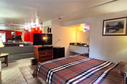 a hotel room with a bed and a kitchen at Saratoga Motel By Capital O Near Midway Airport Chicago IL in Burbank