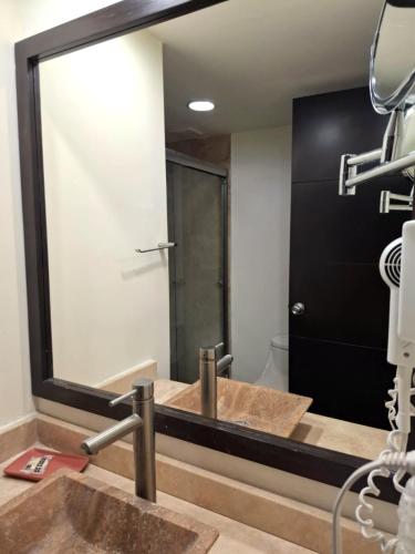 ein Badezimmer mit zwei Waschbecken und einem großen Spiegel in der Unterkunft Hotel ALO! Express in Torreón