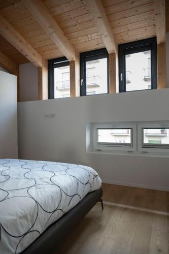 a bedroom with a bed in a room with windows at Ivrea Centro - Attico Top in Ivrea