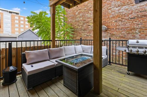 eine Terrasse mit einem Sofa und einem Grill auf einer Terrasse in der Unterkunft Mass Ave Retreat with Big Patio and Free Parking in Indianapolis