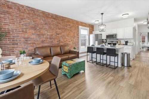 ein Wohnzimmer und eine Küche mit einer Ziegelwand in der Unterkunft Mass Ave Retreat with Big Patio and Free Parking in Indianapolis