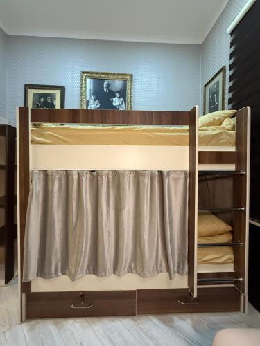 a bunk bed with a curtain in a room at Caspian Hostel in Baku