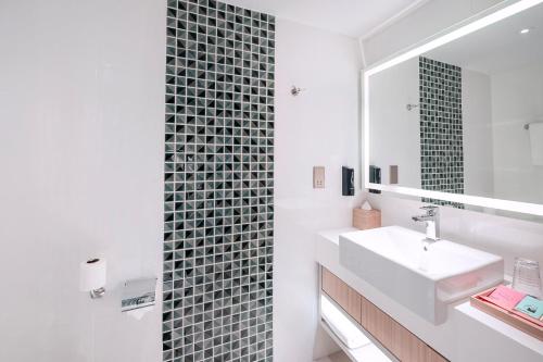 un bagno con lavandino e specchio di OZO Medini Malaysia a Nusajaya
