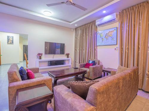 un soggiorno con due divani e una TV di KAJAZZ properties a East Legon