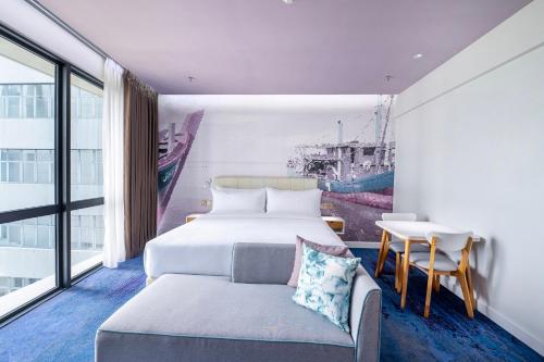 a bedroom with a bed and a table and a desk at OZO Medini Malaysia in Nusajaya