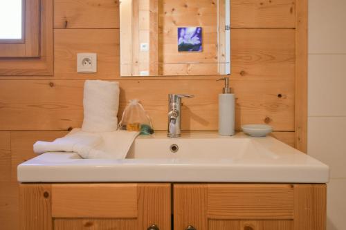 Chalet - Arosa في لو غراند بورناند: حمام به حوض غسيل أبيض ومرآة