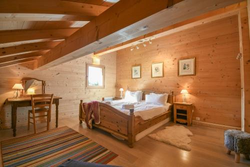 Chalet - Arosa في لو غراند بورناند: غرفة نوم مع سرير في كوخ خشبي