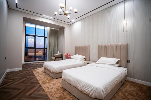 a bedroom with two beds and a chandelier at شاليه مسا الفندقي in Buraydah