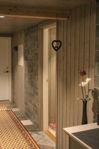 a room with a vase of flowers and a heart hanging on the wall at Åsjord Farmhouse in Oldra