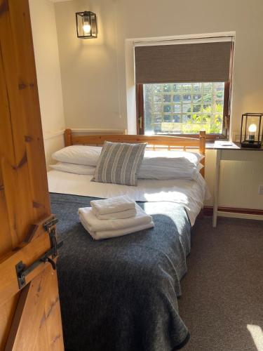 two beds in a room with towels on the bed at Craven Garth Cottages in Rosedale Abbey