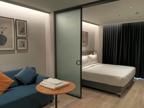 ein Schlafzimmer mit einem Bett und einer blauen Couch in der Unterkunft Luxury Studio, 1 Bed, Separate Study Gourmet Kitchen Prime Location in Bangalore