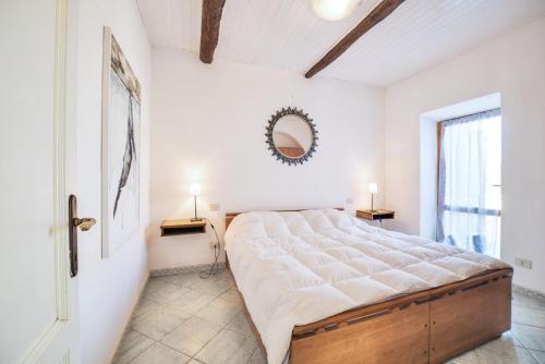 a bedroom with a large bed and a mirror at Patresi Mare - Goelba in Mortigliano