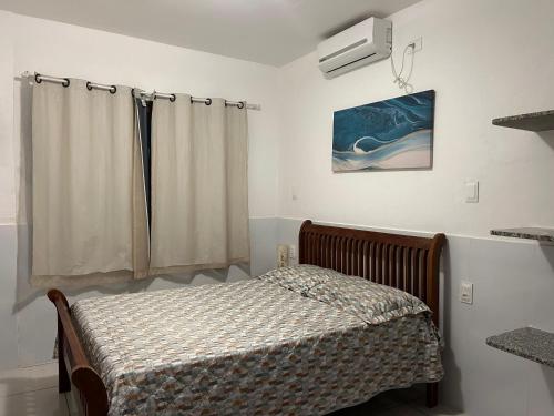 a small bedroom with a bed and a window at Casa Aconchegante Tamandaré in Tamandaré