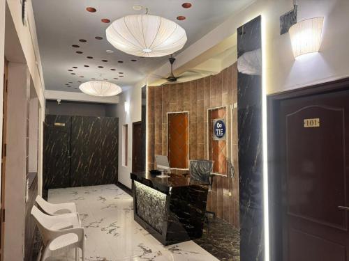 Un vestíbulo con un mostrador de recepción, sillas y luces. en La Coromandel Luxury - TIE, en Pondicherry