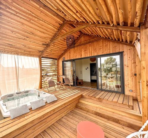 une maison en bois avec un jacuzzi dans une chambre dans l'établissement DAMONA LODGES, à Vairé
