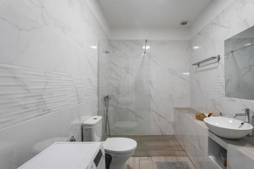 Un baño blanco con inodoro y lavabo. en 2 Apartamentos Omanai Tenerife Sur, en Las Galletas