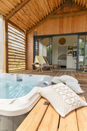 a hot tub on a wooden deck with a house at DAMONA LODGES in Vairé