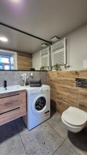 a bathroom with a washing machine and a toilet at Apart Complex Green Rewolucji 27 in Łódź