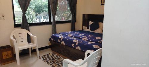 Un pequeño dormitorio con una cama y una silla. en Amri's Villa, en Mount Abu