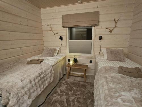 two beds in a room with a window at Arctic Circle Aurora Guesthouse in Rovaniemi