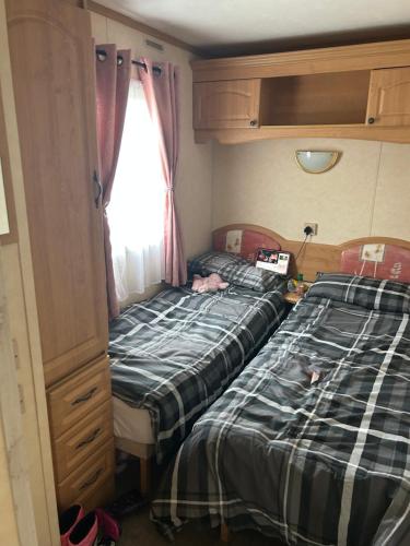 two twin beds in a small room with a window at My happy place in Greencastle